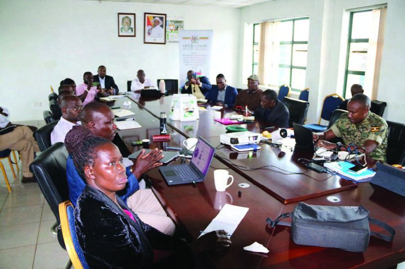Group of men in meeting room with laptops and banner in background